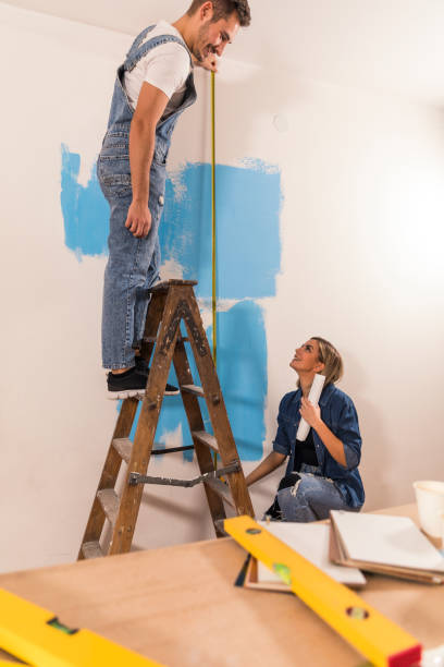 istock Teamwork when measuring the height of the wall 1290357292