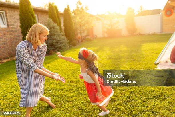 Mother And Daughter Chasing Each Other While Playing Blind Mans Buff Stock Photo - Download Image Now
