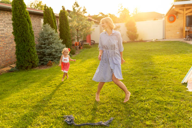 istock Mother and daughter chasing each other in the backyard 1290359069