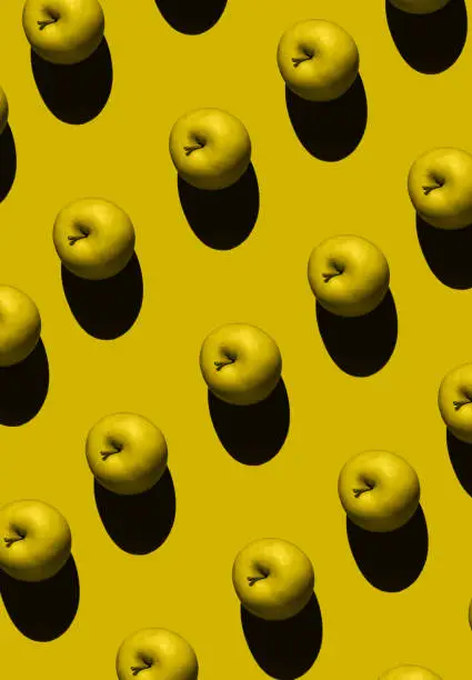 Colorful fruit pattern of yellow apple on yellow background. Top view