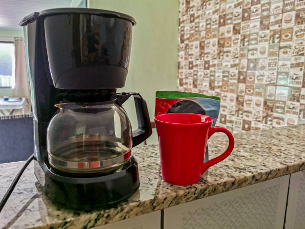 istock Coffee machine and red cup on table in the kitchen. 1290365722