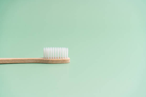 istock Environmentally friendly bamboo wood antibacterial toothbrush on light green background 1290367299