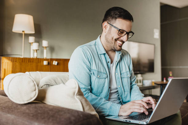 istock Smiling man is working from home in living room 1290367831