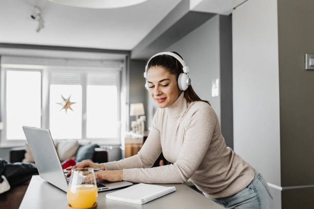 istock Smiling woman is working from home on the kitchen counter 1290367897