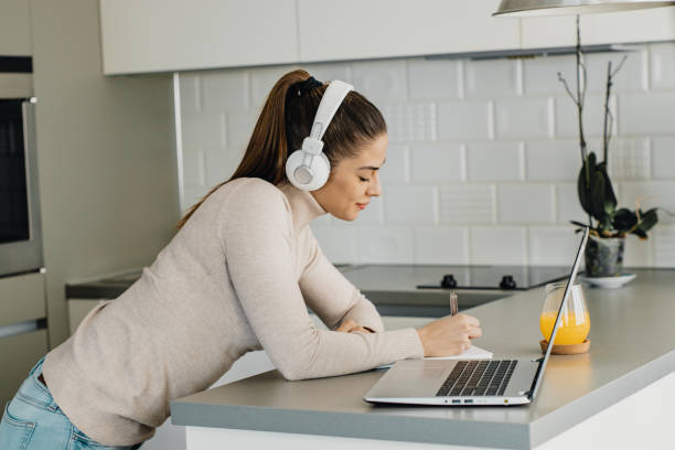 istock Smiling woman is working from home on the kitchen counter 1290368826