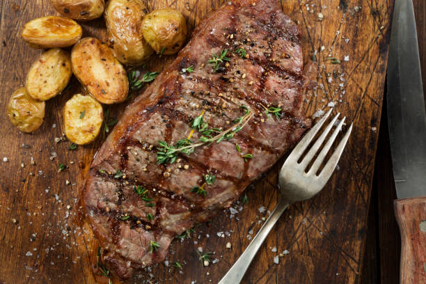 bistecca di controfiletto rara media con patate arrosto - strip steak immagine foto e immagini stock