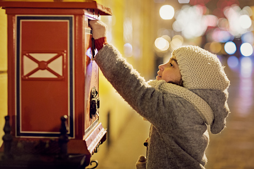 Little girl is sending letter to Santa Claus