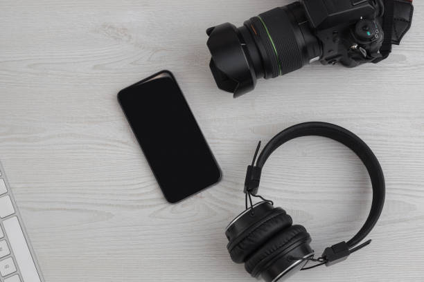 istock desk with a camera, cell phone and a headphones 1290379872