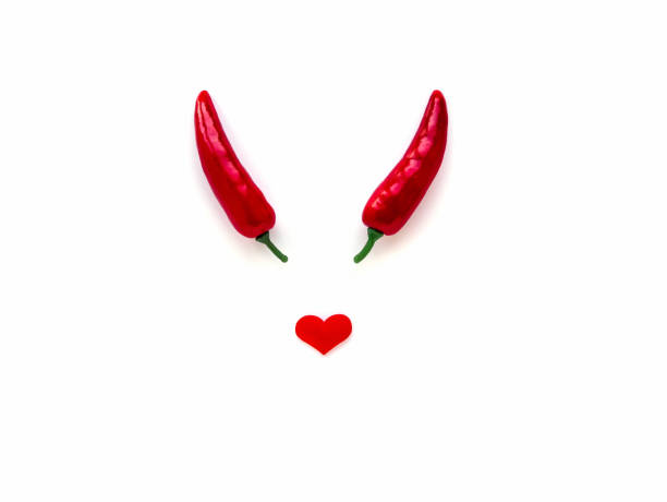 valentinstag-konzept. zwei rote paprika und ein herz auf einem weißen isolierten hintergrund teufel symbol, unfug - devil chili stock-fotos und bilder