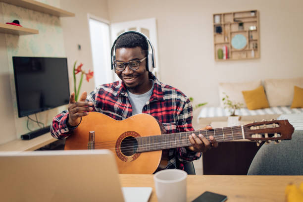 istock Young African-American man having an online guitar class 1290391005