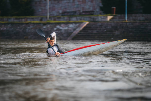 jeune homme musculaire pendant l’entraînement de sprint de kayak sur l’eau immobile - skiff photos et images de collection