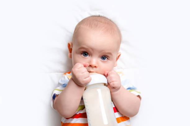 istock Caucasian baby boy with baby milk bottle. 1290394849