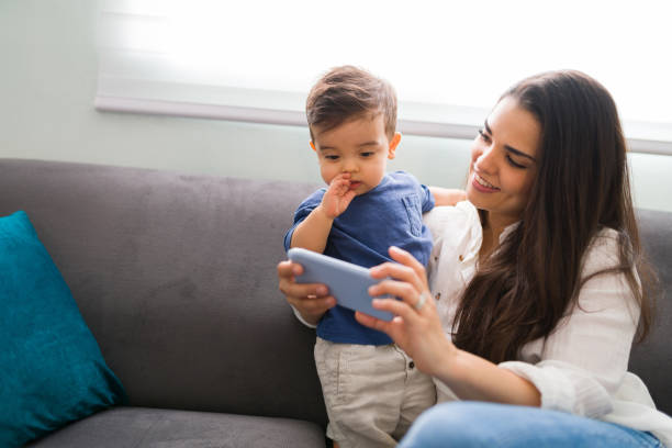 istock Pretty woman and her son using smartphone at home 1290398071