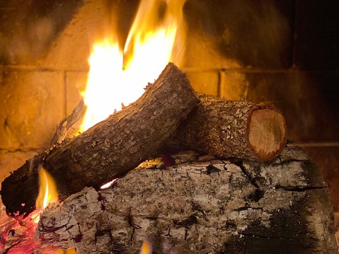 A fire in a fireplace with 3 logs
