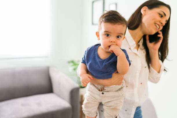 lindo bebé con mamá hablando por teléfono - finger in mouth fotografías e imágenes de stock