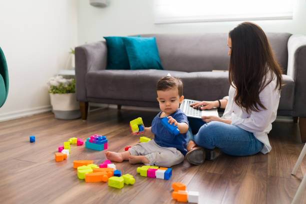 istock Baby playing with blocks and mother working on laptop 1290398567