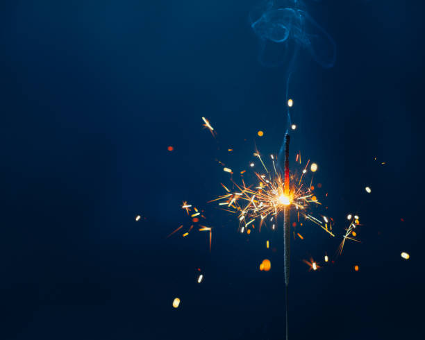 istock shiny fire sparkler on dark blue background with copy-space 1290412810