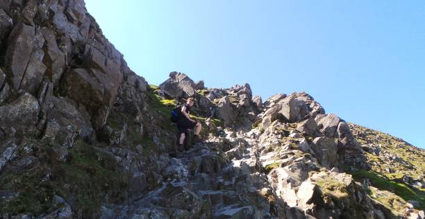 Climbing the rocky terrain Climbing the rocky terrain of Helvellyn striding edge stock pictures, royalty-free photos & images