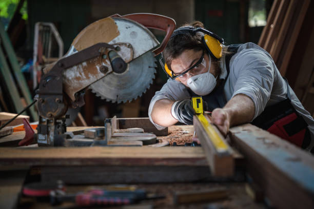istock caucasian carpenter working in wood workshop meaturing woodwork with tape measure on work table. concept of carpenter work in wood workshop 1290426592