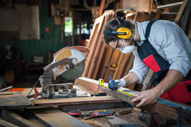 istock caucasian carpenter working in wood workshop meaturing woodwork with tape measure on work table. concept of carpenter work in wood workshop 1290426629