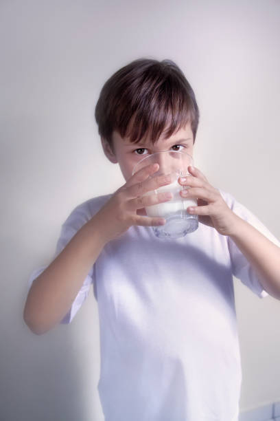 ミルクを飲む美しい十代の少年の肖像画を閉じる - children only healthy lifestyle vertical close up ストックフォトと画像