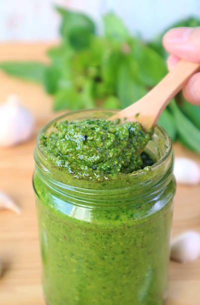 Spoon Scooping Vibrant Green Fresh Basil Pesto Sauce or Pesto Alla Genovese