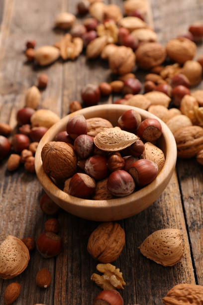 istock almond on wood background- top view 1290444462