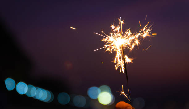 istock Hand holding a sparkler on beach during sunset with bokeh light background. New year or Christmas celebration concept. 1290445770
