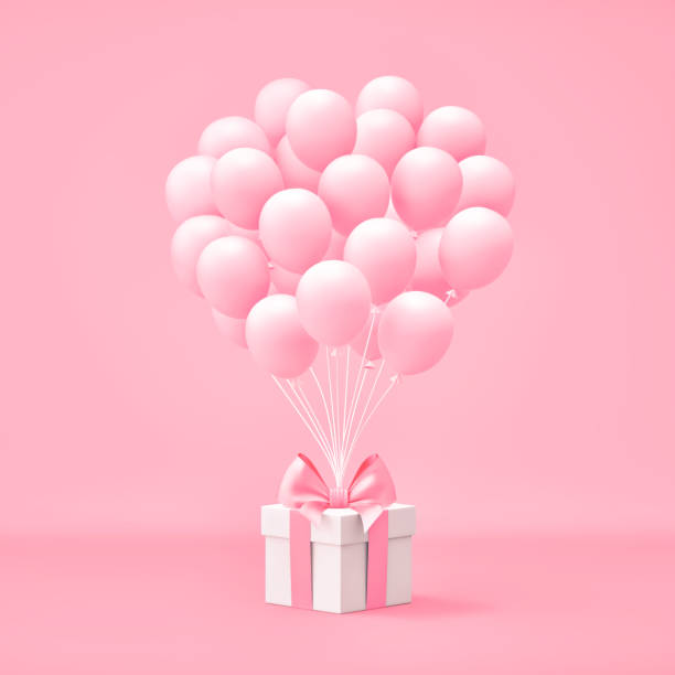 istock White gift box with pink bow and balloons on pink background 1290446515