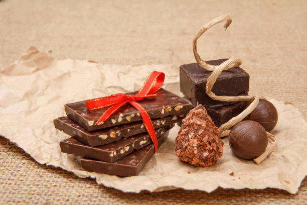 istock Chocolate bars with nuts and chocolate candies on pack paper. 1290447652
