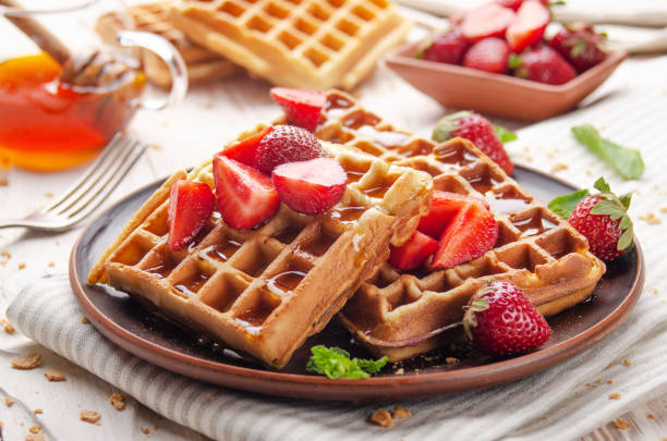 istock Homemade crispy Belgian waffles served with strawberries and honey 1290451306