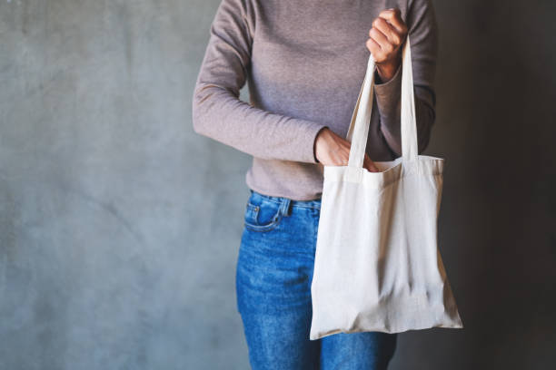 istock a woman carrying and using a white fabric tote bag for reusable and environment concept 1290451821