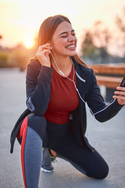 istock Modern young woman with cellphone making pause during jogging / exercise. 1290452792