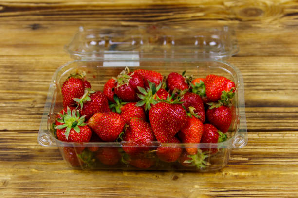 istock Fresh strawberry in plastic box on a wooden table 1290453922