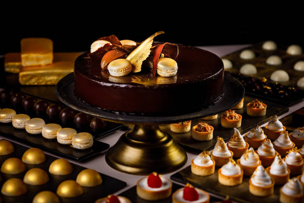 Large chocolate cake served with macaroons, raspberry and lemon mini tarts and chocolate amuse bouche Large chocolate cake served with macaroons, raspberry and lemon mini tarts and chocolate amuse bouche. amuse stock pictures, royalty-free photos & images