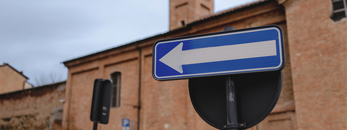 Horizontal banner with Traffic sign in a European city street. One way turn on the left sign.
