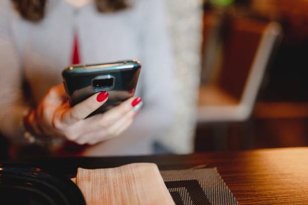 istock Close-up unrecognizable woman hands sitting in a restaurant table holding tablet. 1290457152