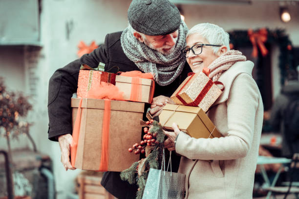 istock Senior couple at Christmas shopping, holding present's and gift boxes 1290458024