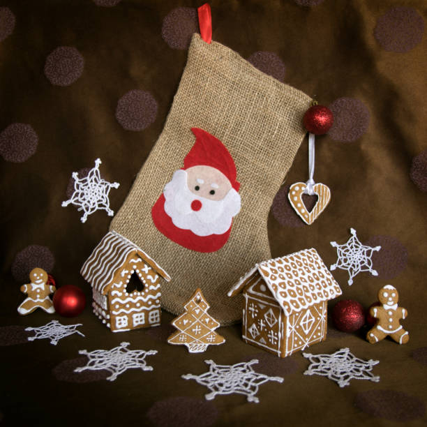 Christmas gingerbread houses with gingerbread men and cookie in the form of a New Year's tree beside sock with Santa on a background