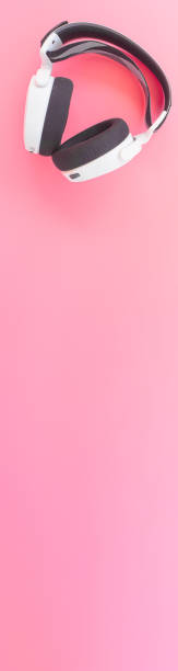istock White music headphones on pink background. web banner size. 1290458530