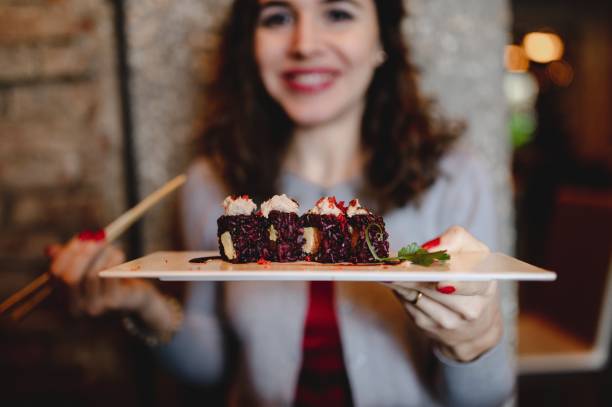 istock Woman with uramaki sushi plate. 1290458638