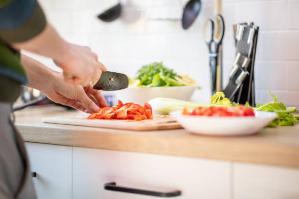 istock Chopping red bell pepper with kitchen knife on cutting board 1290464270