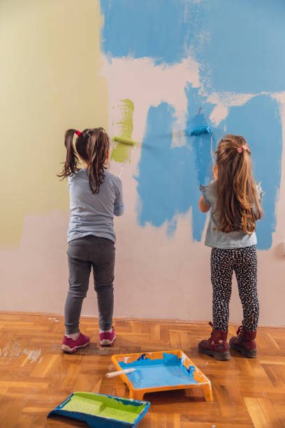 istock Wall painting in progress by two little girls 1290464883