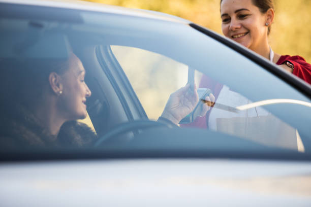 istock Woman paying for her drive through order 1290466786