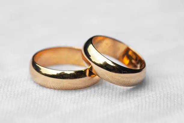 Couple of wedding rings laid on a white white tablecloth, wedding reportage