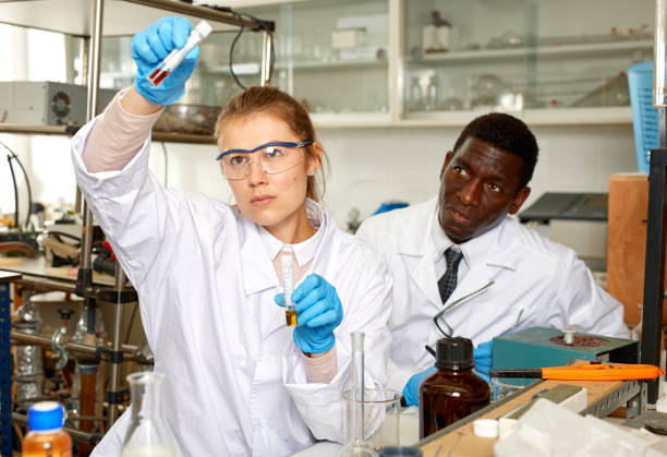 istock Focused woman lab technician checking for result of  experiment 1290469519