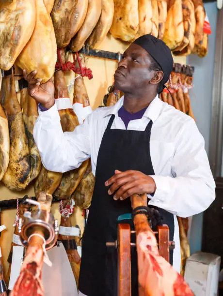 Photo of Salesman checking quality of Spanish ham