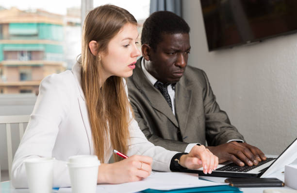 istock Male and female colleagues working  with laptop and documents at table 1290472378