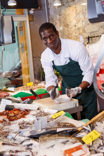 istock Salesman preparing fish for sale 1290473639