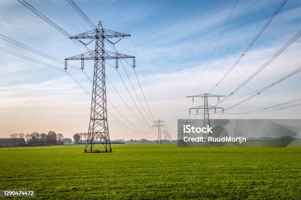 Two Seemingly Endless Rows Of Electricity Pylons In A Meadow Stock Photo - Download Image Now